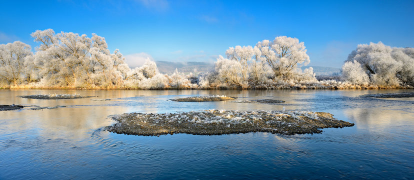 Winter am Flu&szlig;, mit Raureif bedeckte B&auml;ume und kleine Inseln