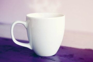 white cup on purple wooden table