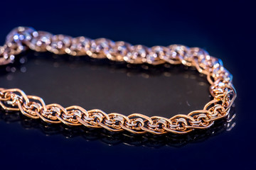 expensive female gold chains, isolated on dark blue.
