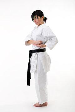 Young black belt fighter training Karate. Isolated woman portrait on white background