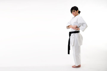 Young black belt fighter training Karate. Isolated woman portrait on white background