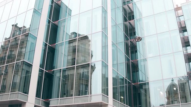 Distorted reflection of old building in modern glass facade of office center in Paris. Old and new, opposites concepts. 4K steadicam video