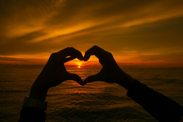 Silhouette of love and heart and beautiful sunset over the sea
