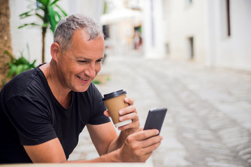 Business talk on a go. Cheerful man holding coffee cup and talking