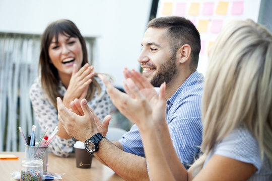 Business people clapping hands in workshop