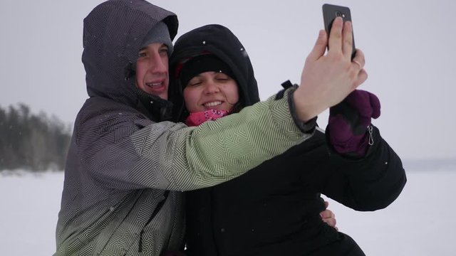 couple in love posing on a camera in the winter, around a frozen lake, 4k