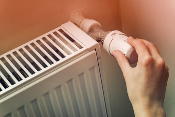 Hand Adjusting The Knob Of Heating Radiator