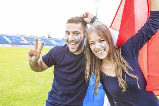 Young couple with face paint and French flag