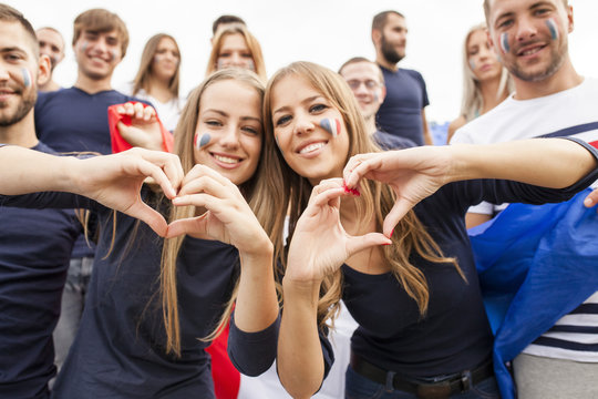 Female soccer fans forming heart with hands