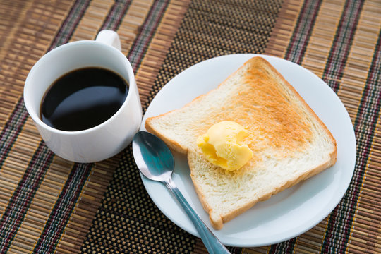 Served table for breakfast with toast, coffee and butter on tabl