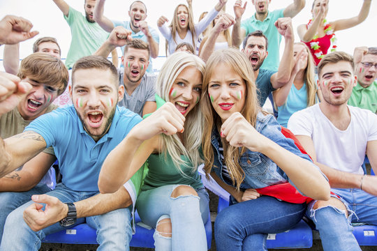 Group of soccer fans in stadium cheering and shouting