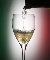 Glass with champagne isolated on background with colors of the Italian flag