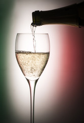 Glass with champagne isolated on background with colors of the Italian flag