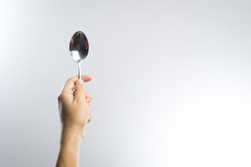 Man hand holding a silver spoon