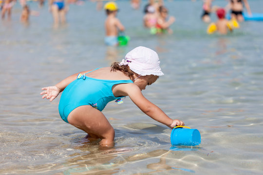 Adorable Toddler Girl Playing With Beach Toys In Blue Sea