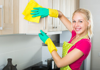 blond girl cleaning surfaces at kitchen