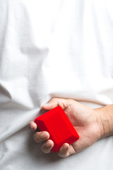 A man Hand holding a Red velvet box