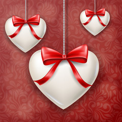 Hanged white hearts with red bows for Valentine's day