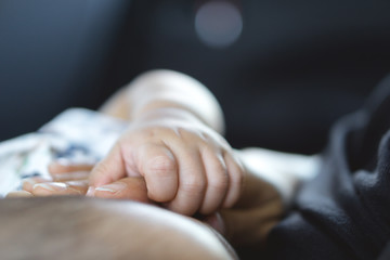 A year old Asian baby holding hand with his mother