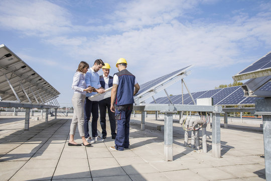 Architects and construction workers inspecting solar power station