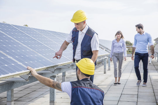 Architects and construction workers inspecting solar power station