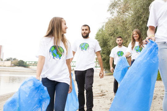 Teenage volunteers doing garbage cleanup on riverbank