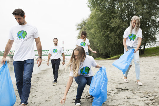 Teenage volunteers doing garbage cleanup on riverbank