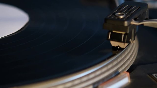Record player playing an old fashioned vintage vinal record. The needle is being put on the record.