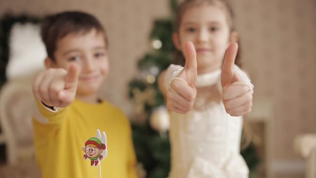Beautiful little girl and boy show a thumbs up and smiling