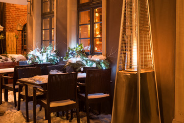 Street cafe with fireplace by night in Gdansk in winter time. Poland, Europe.