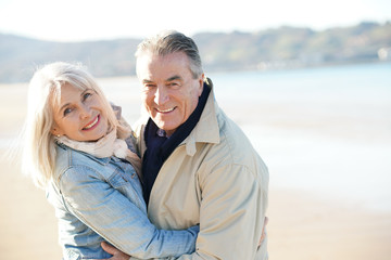 Portrait of senior couple having fun at the beach, wintertime