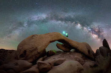 Man on top of Arch Rock under the milky way 