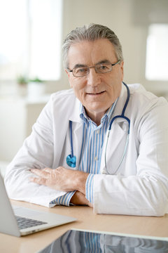 Portrait of senior doctor sitting in medical office