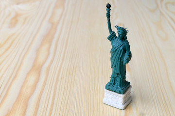 American symbol - Statue of Liberty. New York, USA on wooden table with background. © narin_nonthamand