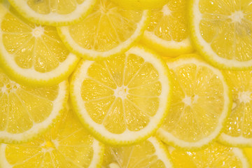 Fresh lemons background. Yellow food background. Juicy slices of lemon. Top view