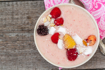 Pink smoothie bowl with raspberries and coconut. Love for a healthy raw food concept.