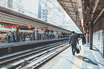 businessman arriving at the train station in the morning sunligh