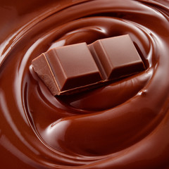 Melted hot liquid chocolate with chocolate pieces. Background.