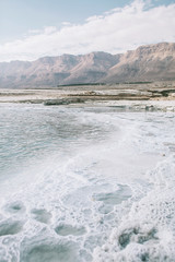 Scenery of Dead sea salty white shore and mountains, vertical orientation
