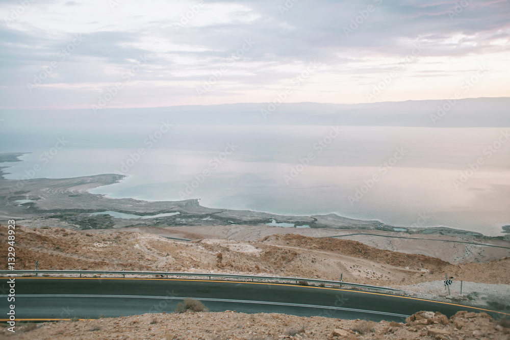 Wall mural sunset in the mountains, view from a hill to the sea and a desert