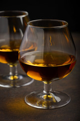 Glass of brandy or cognac on the old rusty background, selective focus, vertical, 