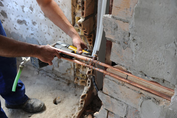 Fontanero empalmando tuberías de pvc con tuberías de cobre