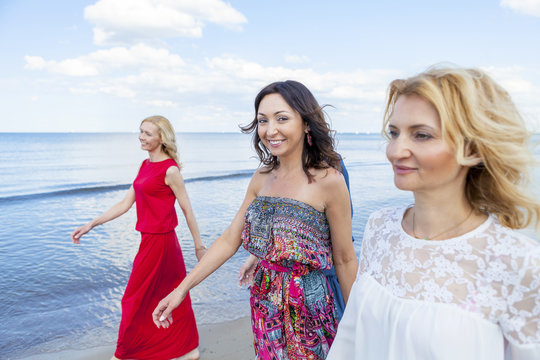 Group of women take a walk along the beach