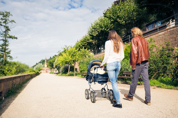 Young Parents With Baby Stroller In The Park