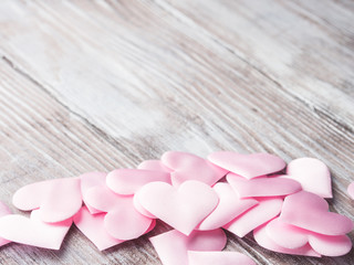 Pink hearts on textured wooden table. Valentine's mother day or baby birthday greeting card. Copy space