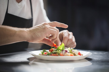 Obraz na płótnie Canvas Chef hands preparing vegetable salad