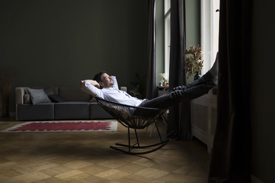 Man relaxing on rocking chair in his living room