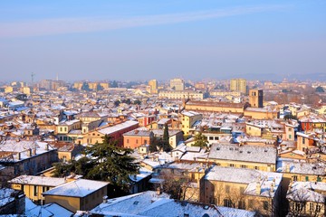 View over the city rooftops with sunlight and snow. Brescia, Italy.