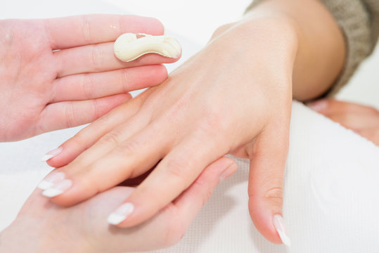 Hand cream application at manicure salon