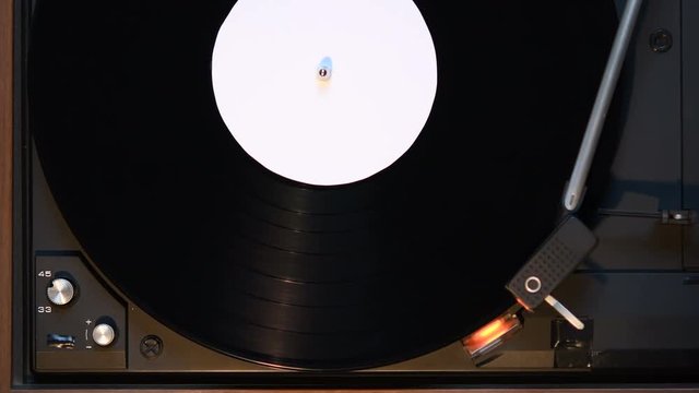 Record player playing an old fashioned vintage vinal record. The needle is being put on the record.